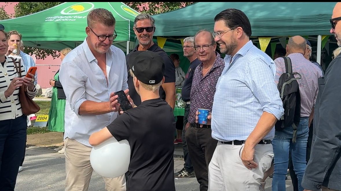Linus Bylund (SD) hjälper en besökare i Piteå att ta en bild tillsammans med Jimmie Åkesson (SD).&nbsp;FOTO: Riks