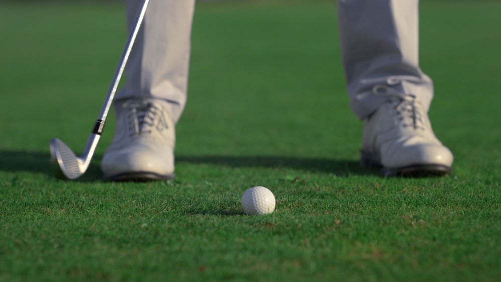 athlete-legs-play-golf-game-on-green-game-field-sport-man-hitting-golfing-ball-close-u-SBI-350149676.jpg